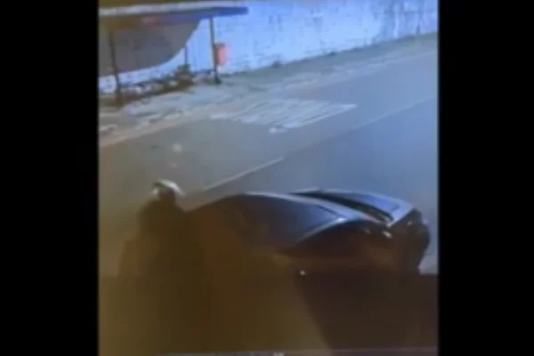 Imagem colorida de uma câmera de segurança mostra um suspeito de capacete embarcando em um carro prata - Metrópoles