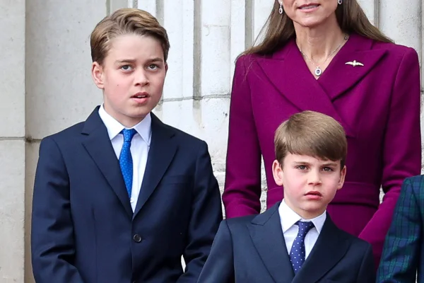 Foto colorida de dois meninos de terno olhando para algo - Metrópoles