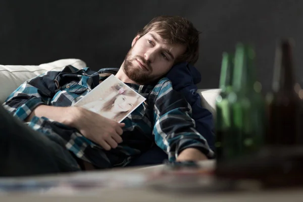homem triste segurando foto de mulher