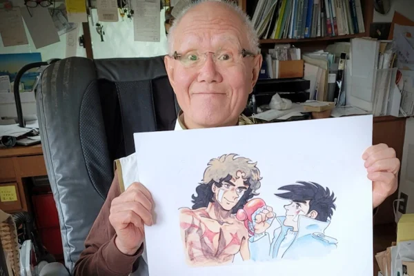 Imagem colorida mostra Tetsuya Chiba segurando um desenho de Mangá - Metrópoles