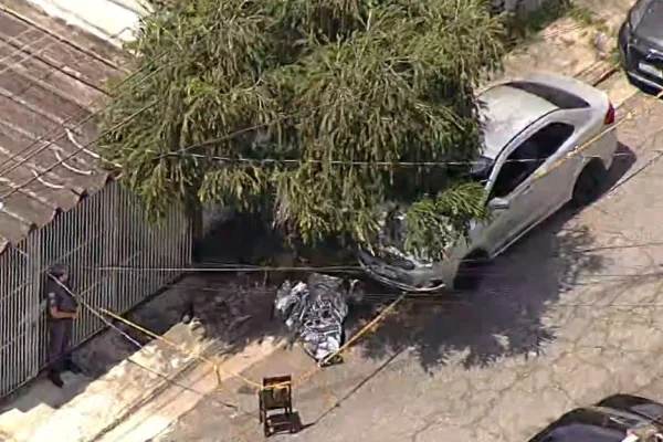 Imagem aérea de corpo de homem morto com chave de fenda caído na rua coberto por manta metálica - Metrópoles