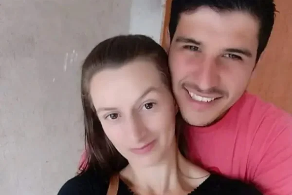 foto de um casal paranaense ela vesta uma blusa preta e ele uma camisa rosa