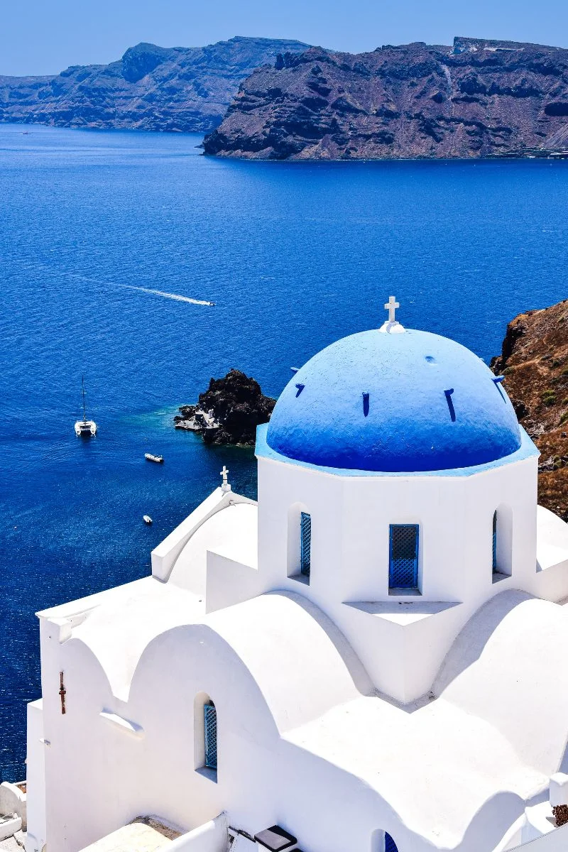 Igreja ortodoxa grega com a tradicional cúpula azul, na ilha de Santorini, na Grécia, com vista para o Mar Egeu Igreja ortodoxa grega com a tradicional cúpula azul, na ilha de Santorini, na Grécia, com vista para o Mar Egeu