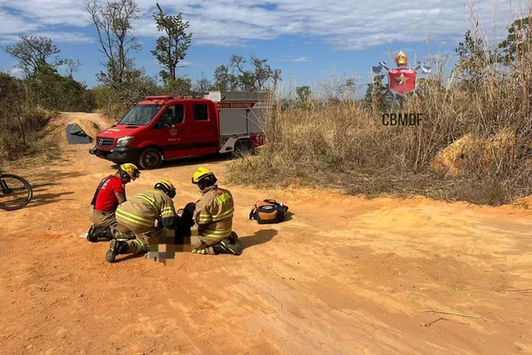 Imagem colorida mostra ciclista ao chão sendo socorrido