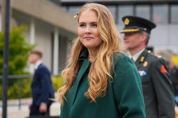 Foto colorida de mulher loira com casaco verde - Metrópoles