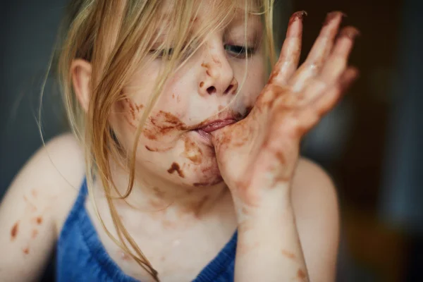 criança comendo chocolate