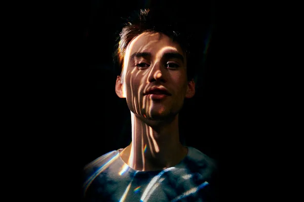 Jacob Collier. Ele é um homem branco, está no escuro com sombras no rosto - Metrópoles