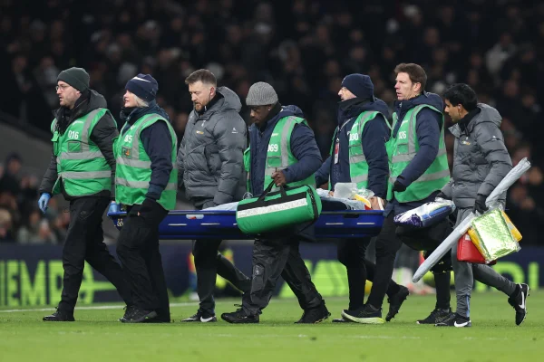 Foto colorida de Bentancour, do Tottenham, deixando o gramado de maca - Metrópoles
