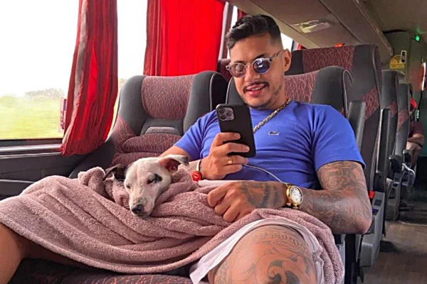 Rapper Hungria sentado no onibus com cachorro no colo