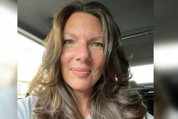 Foto colorida de mulher com olhos claros e sorrindo para uma selfie - Metrópoles.