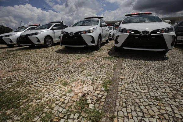 Fotografia colorida mostra viaturas estacionadas na Praça dos Três Poderes