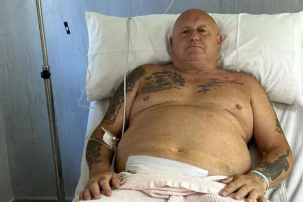 Homem deitado em maca de hospital com curativo na barriga - Metrópoles