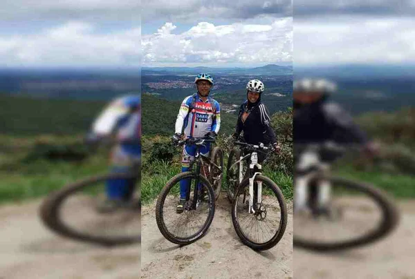Casal em bicicleta sorrindo para foto