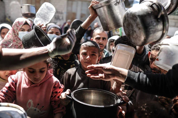Imagem colorida mostra palestinos famintos esperando por doação de comida Israel - Metrópoles