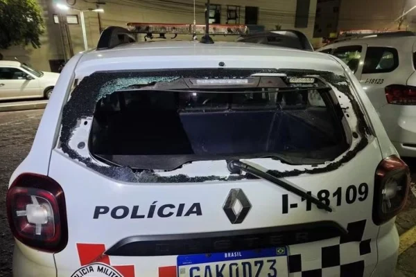 Imagem colorida de vidro de viatura policial quebrado. Metrópoles