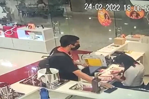homem com mão prestes a pegar celular em cima de balcão e mulher distraída