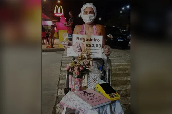 Jovem com paralisia vende doces em cadeira de rodas para sustentar filha