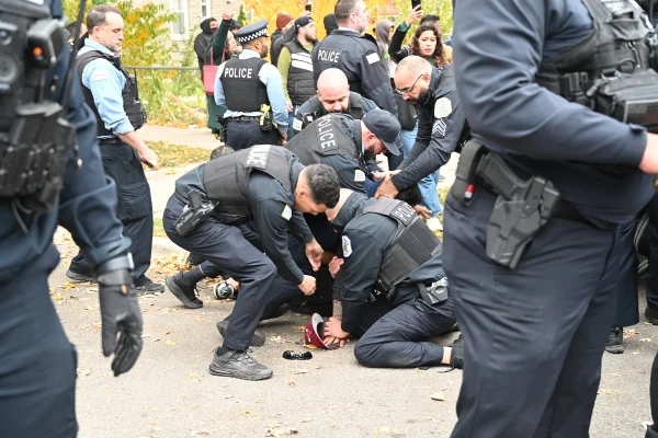 Policiais intervêm com firmeza junto a uma pessoa caída no chão durante uma operação do Serviço de Imigração e Alfândega dos Estados Unidos (ICE)