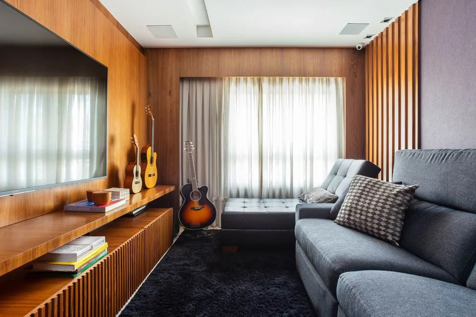 Quebrando a inspiração da área de recepção, a sala de tv tem cores mais escuras para um ar intimista Quebrando a inspiração da área de recepção, a sala de tv tem cores mais escuras para um ar intimista