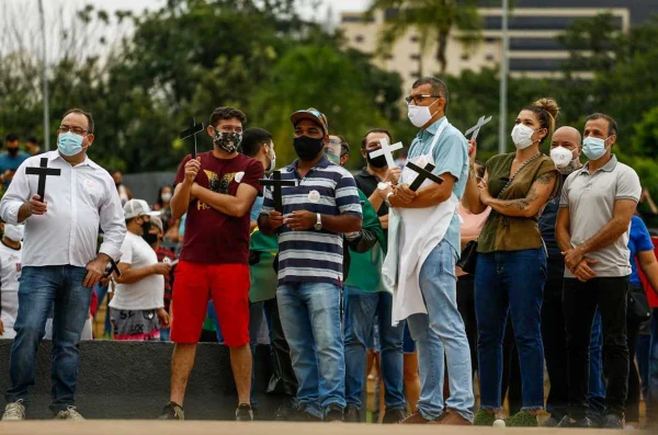 donos e funcionários de bares de goiânia, goiás, em protesto em frente a prefeitura, segurando cruzes e cartazes
