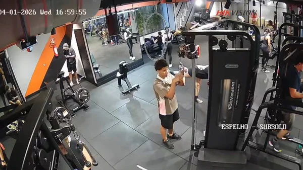 mulher se acidentando com peso em academia