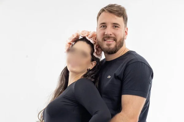 Imagem colorida de uma mulher com rosto borrado e um homem de camiseta preta