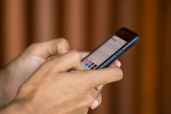imagem colorida de mão segurando um telefone celular