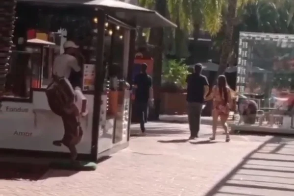O frame colorido mostra Fernando e Maiara andando juntos, de mãos dadas