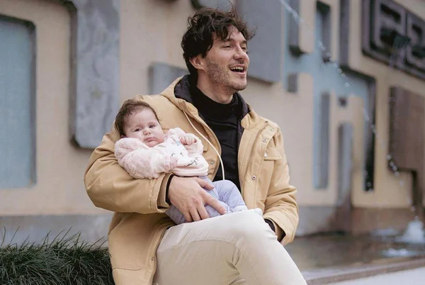 Foto colorida de Eliezer com a filha, Lua Di Felice, no colo - Metrópoles