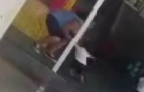 Imagem pouco nítida de mulher com colete azul puxando criança pelo braço - Metrópoles