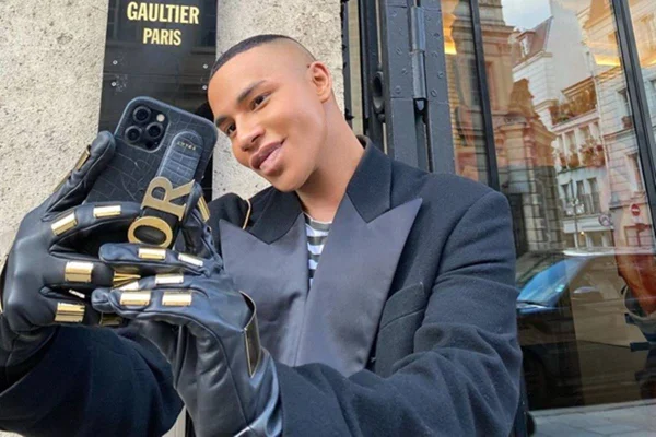 Na imagem, o estilista Olivier Rousteing posa em frente a loja da Jean Paul Gaultier