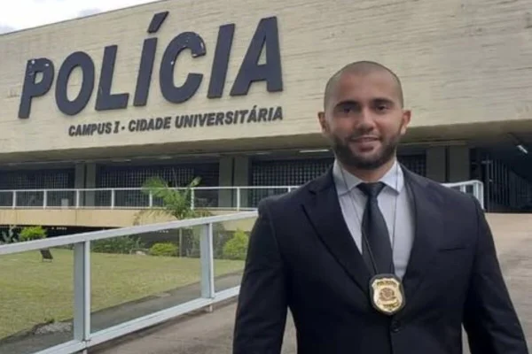 Homem branco de terno e gravata em frente a prédio com a palavra Polícia - Metrópoles