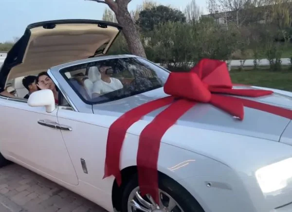 Georgina, mulher de Cristiano Ronaldo, dá ao marido um carro de um mihão e meio de reais de presente. Na imagem, a família aparece dentro do conversível enrolado em fita vermelha de presente - Metrópoles