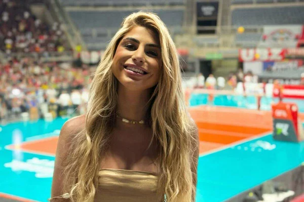 Mulher loira em frente a uma quadra de vôlei - Metrópoles