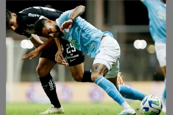 Foto colorida mostra dois jogadores em disputa durante jogo entre Bahia e Corinthians