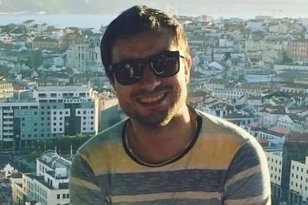 Ele posa para foto com um óculos de sol