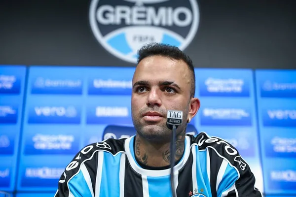 Homem, vestido com camisa com detalhes em azul, preto e branco, fala ao microfone - Metrópoles