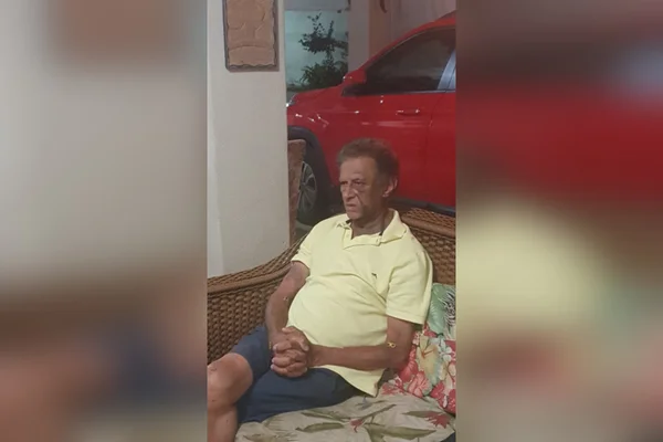 idoso sentado com as mãos cruzadas e o rosto inchado