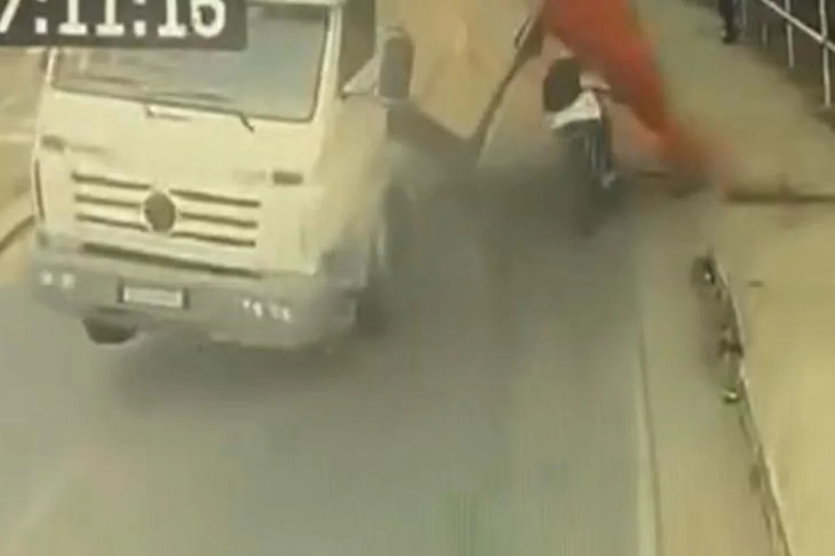 Ciclista fica soterrado após caminhão bater e tombar com carga de terra