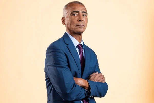 O senador Romário Faria de braços cruzados, terno azul e gravata