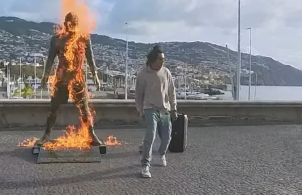 Imagem colorida de homem ateando fogo em estátua de Cristiano Ronaldo- Metrópoles