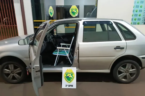 imagem colorida mostra carro Gol de cor prata com cadeira de praia no lugar no banco do motorista