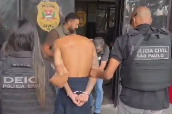 Imagem colorida mostra homem apontado como chefe de quadrilha que invade casas em SP sendo preso por policiais do Deic - Metrópoles