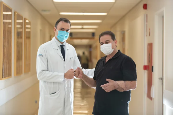 fotografia colorida de médico e paciente no corredor de um hospital