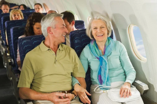 casal de idosos sentados em poltrona de avião