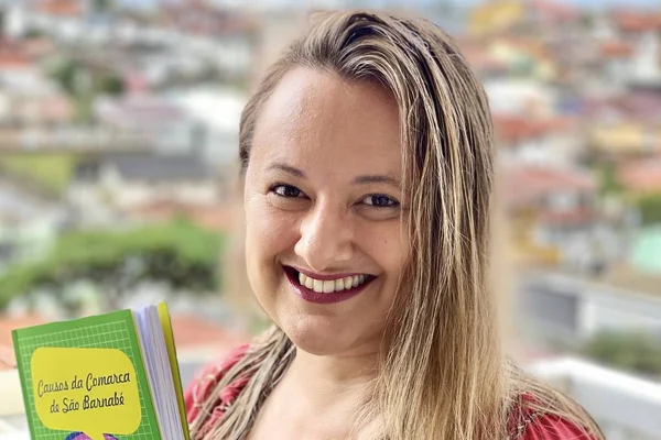 A escritora Saíle Barreto posa com o livro de ficção Causos da Comarca de São Barnabé