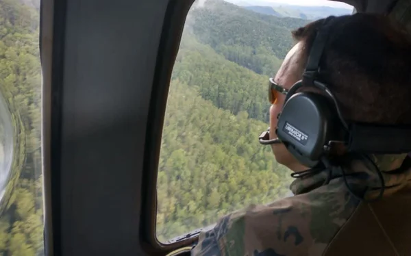 Foto colorida de militar da FAB sobrevoando Serra do Mar em busca de helicóptero desaparecido em São Paulo - Metrópoles