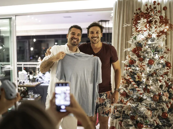 Foto colorida de amigos trocando presentes de amigo secreto - Metrópoles