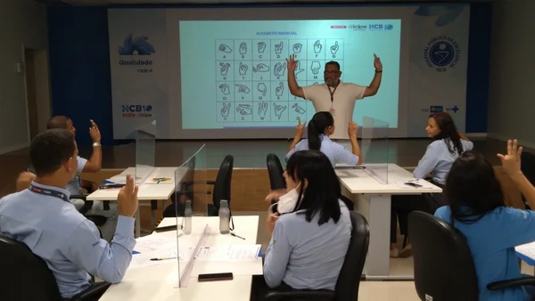 professor ensina Libras para alunos em uma sala