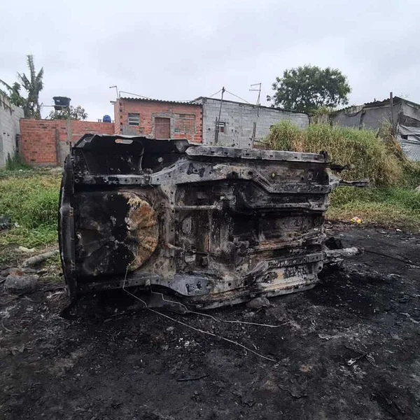 Imagem Colorida mostra carro tombado e queimado - metrópoles